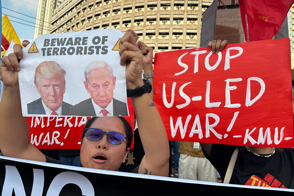 A protester holds a banner with pictures of U.S. President Donald Trump and Israeli Prime Minister Benjamin Netanyahu as they hold a rally in solidarity with Iran in Quezon city, Philippines on Monday, March 2, 2026. (AP Photo/Joeal Calupitan)