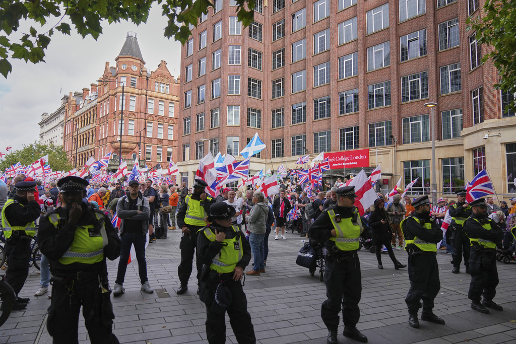 Police officers form a line in front of demonstrators from the Tommy Robinson-led Unite the Kingdom march and rally near Westminster, London, Saturday Sept. 13, 2025. (AP Photo/Joanna Chan)