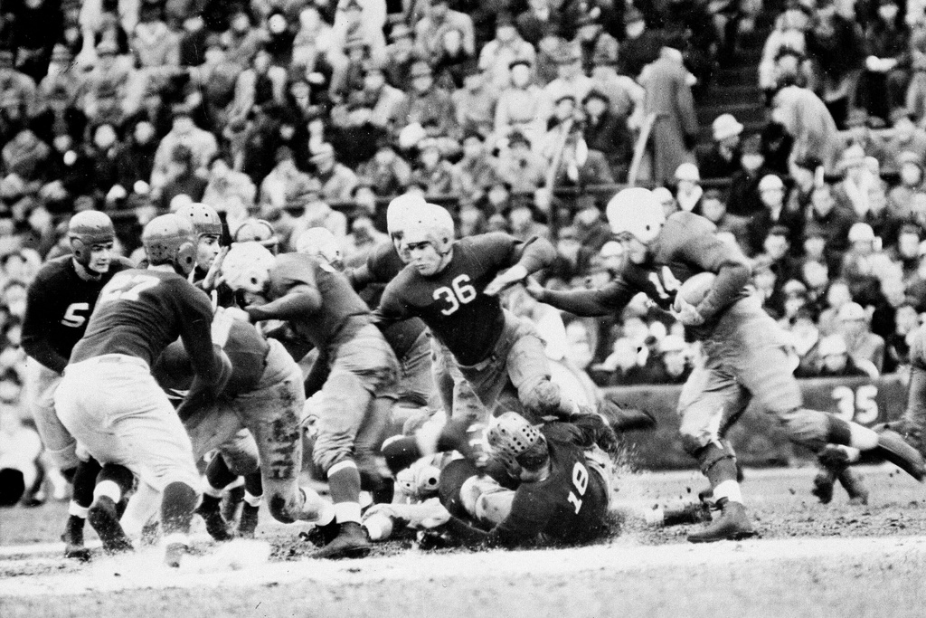 FILE - Team captain, Clint Frank (14) of Yale, swings around the end for a short gain in the first quarter of the Harvard-Yale college football game in Cambridge, Mass., Nov. 20, 1937. (AP Photo/File)
