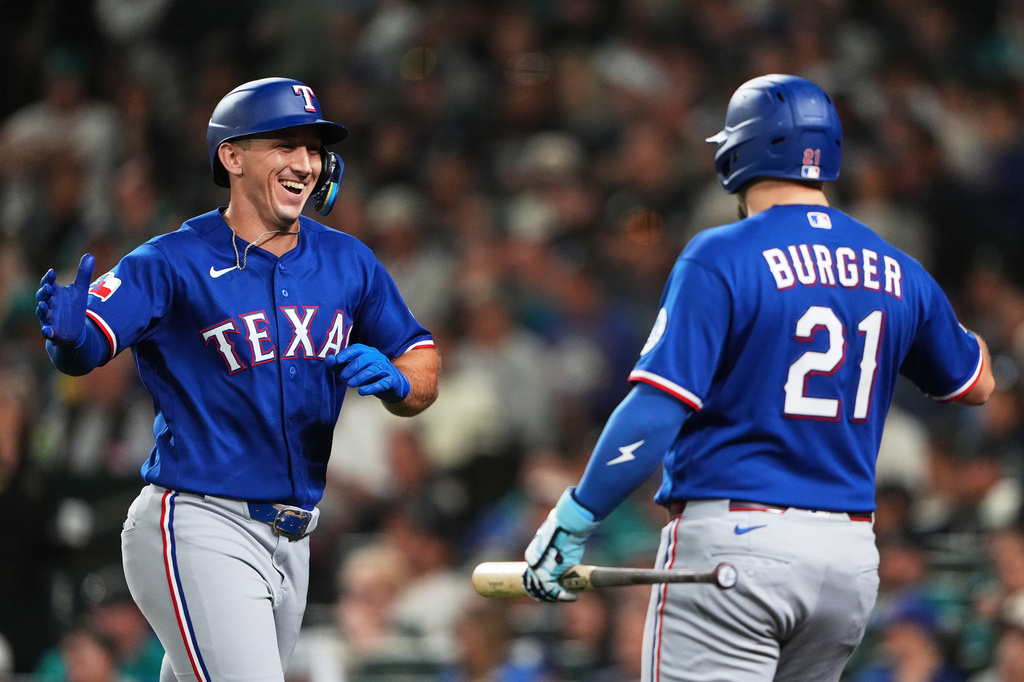 Texas Rangers' Wyatt Langford, left, celebrates his two-run home run with teammate Jake Burger (21) during the fifth inning of a baseball game against the Seattle Mariners, Tuesday, Sept. 8, 2026, in Seattle. (AP Photo/Lindsey Wasson)