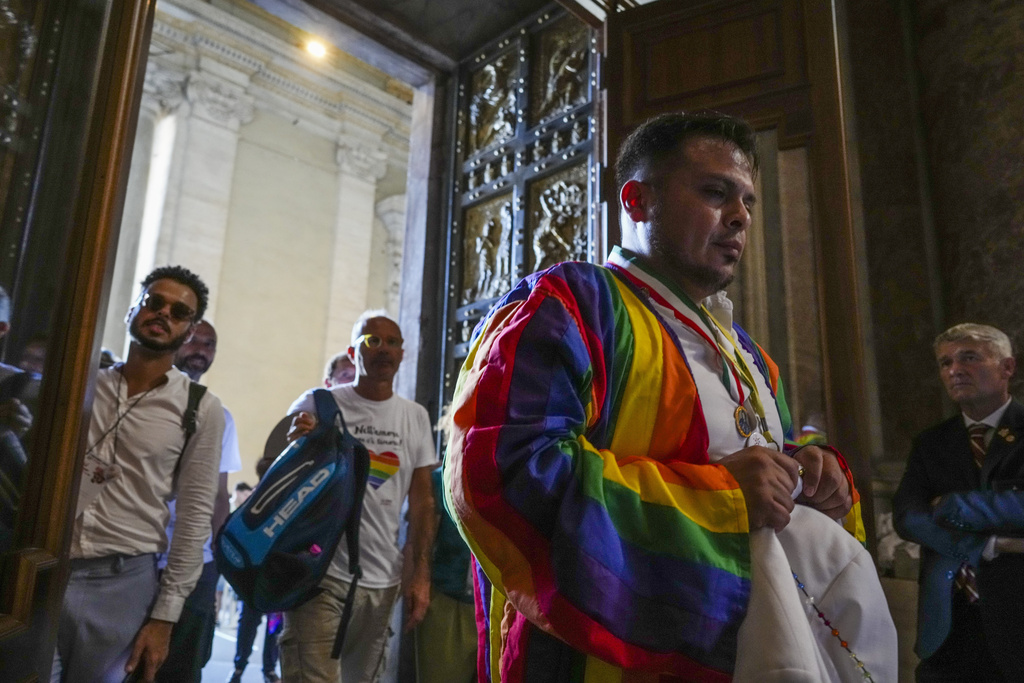 Some of the hundreds of LGBTQ+ Catholics and their families who joined a Holy Year pilgrimage to Rome, celebrating a new level of acceptance in the Catholic Church and crediting Pope Francis for the change, walk through the Holy Door of St. Peter's Basilica at the Vatican, Saturday, Sept. 6, 2025. (AP Photo/Andrew Medichini)