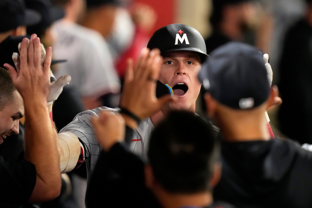 Minnesota Twins' Walker Jenkins is congratulated by teammates in the dugout after hitting a two-run home run during the ninth inning of a baseball game against the Los Angeles Angels, Thursday, Sept. 17, 2026, in Anaheim, Calif. (AP Photo/Mark J. Terrill)