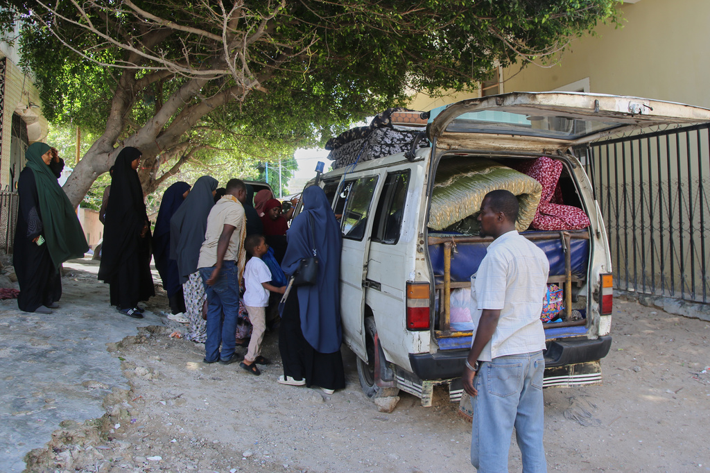 Residents board a vehicle after supporters of opposition political figures and state security forces clashed in Mogadishu, Somalia, Thursday, June 4, 2026. (AP Photo/Farah Abdi Warsameh)