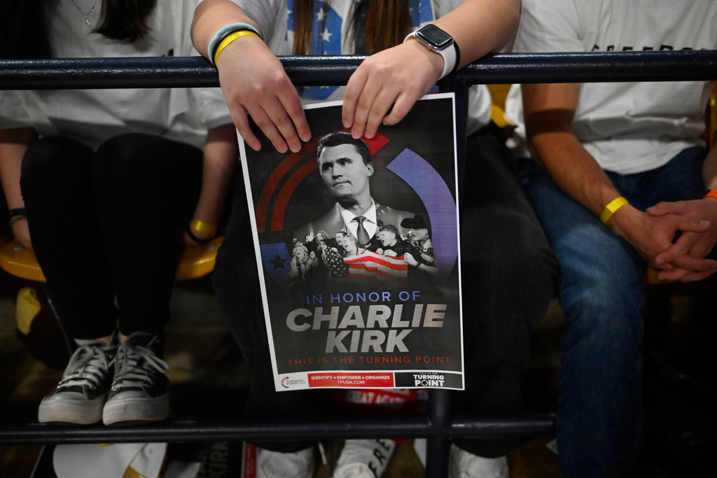 An attendee holds a poster of Charlie Kirk at a Turning Point USA rally at Utah State University, as a part of the organization's push to memorialize Kirk, Tuesday, Sept. 30, 2025, in Logan, Utah. (AP Photo/Alex Goodlett)