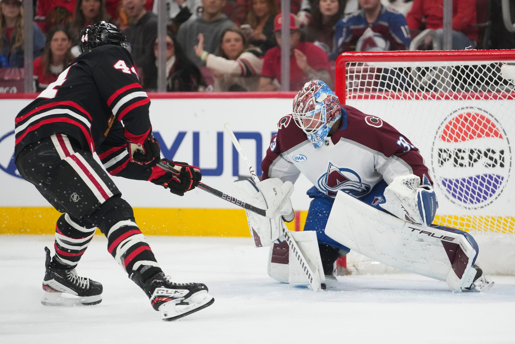 Chicago Blackhawks defenseman Wyatt Kaiser, left, scores against Colorado Avalanche goaltender MacKenzie Blackwood, right, during the second period of an NHL hockey game Friday, March 20, 2026, in Chicago. (AP Photo/Erin Hooley)