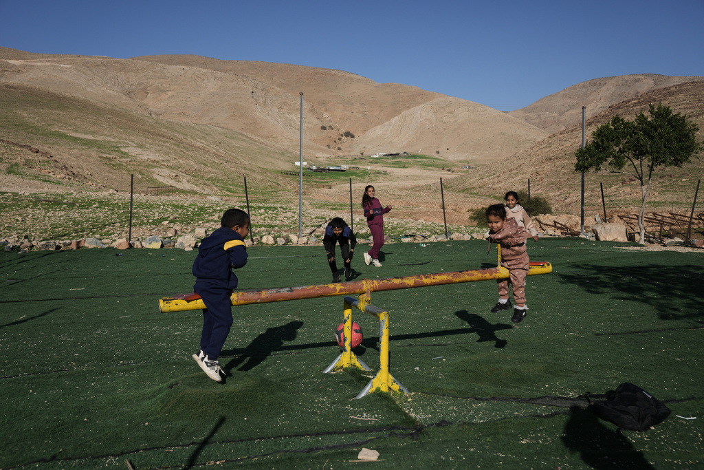 Palestinian children play in the West Bank village of Ras Ein al-Auja, Sunday, Jan. 11, 2026. (AP Photo/Mahmoud Illean)