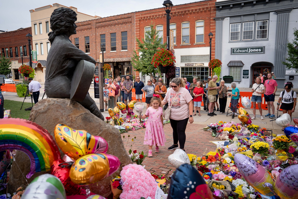 People lay flower at a memorial honoring Dolly Parton in Sevierville, Tenn., Wednesday, Aug. 26, 2026. (AP Photo/Camden Hall)