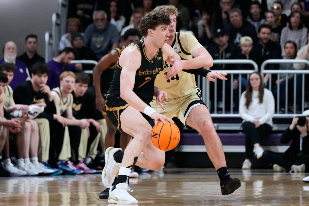 Northwestern forward Nick Martinelli, left, drives as Purdue guard Jack Benter guards during the first half of an NCAA college basketball game in Evanston, Ill., Wednesday, March 4, 2026. (AP Photo/Nam Y. Huh)