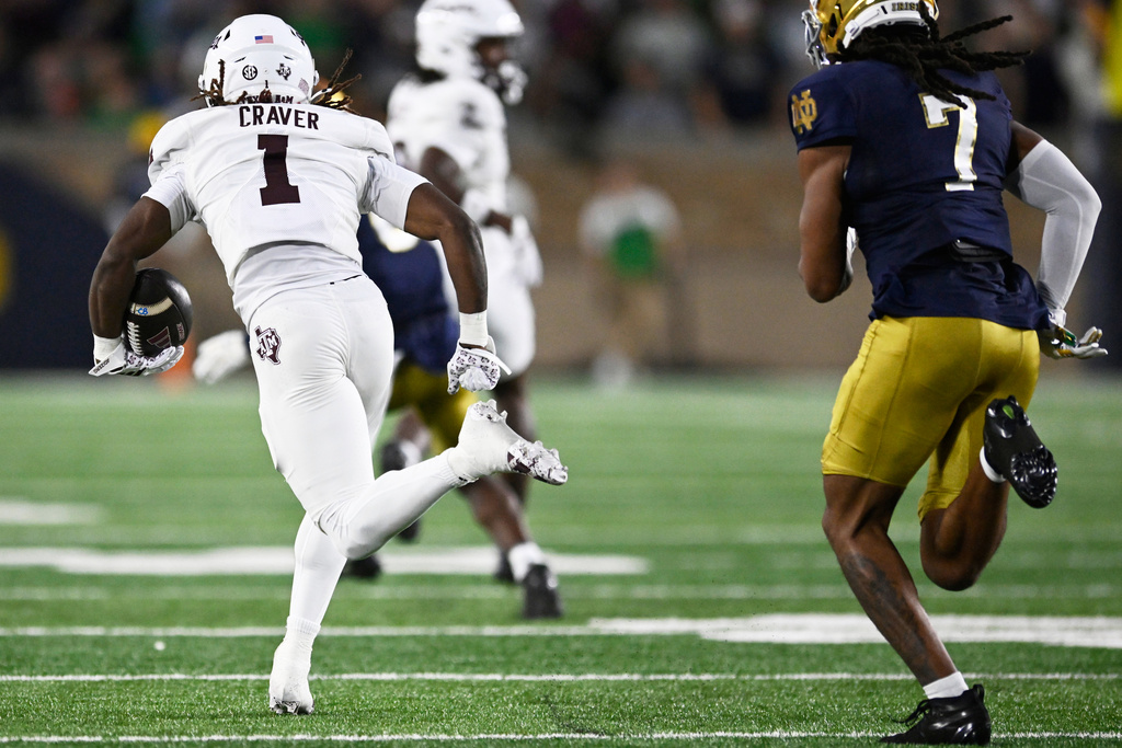 Texas A&M wide receiver Mario Craver (1) rushes for a 86 yard touchdown after catching a pass against Notre Dame's Ty Washington (7) during the first half of an NCAA football game Saturday, Sept. 13, 2025, in South Bend, Ind. (AP Photo/Paul Beaty)