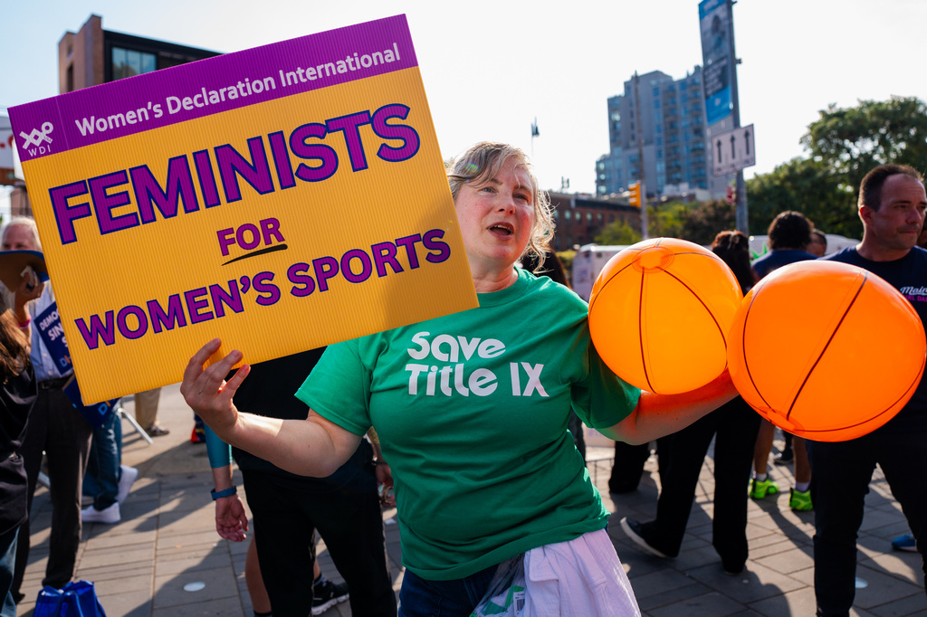 Demonstrators rally against transgender athletes in women's sports outside of Barclay's Center before the WNBA basketball game between the Indiana Fever and the New York Liberty, Saturday, Aug. 22, 2026, in New York. (AP Photo/Angelina Katsanis)