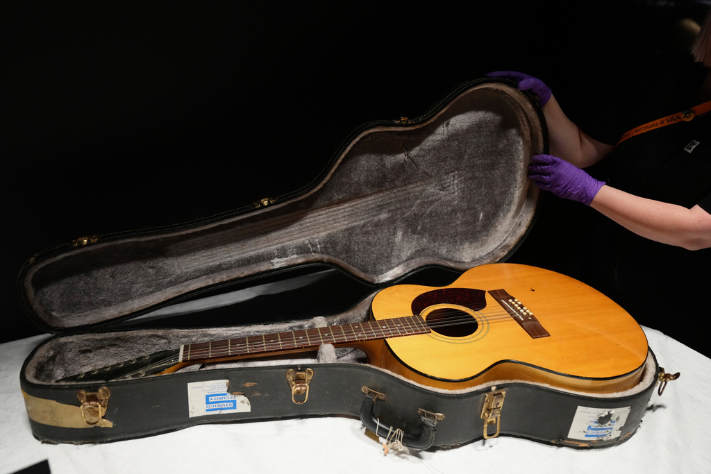 The Harptone 12-string acoustic guitar and case used by David Bowie on Ziggy Stardust and the Spiders from Mars and Let's Dance in 1970, is displayed during a press preview at the David Bowie Centre, a new archive at the V&A East Storehouse in London, Wednesday, Sept. 10, 2025, ahead of its public opening on Saturday. (AP Photo/Joanna Chan)