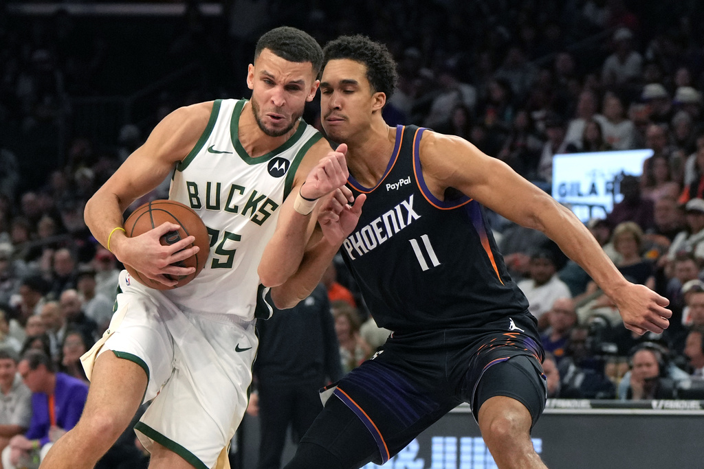 Milwaukee Bucks forward Pete Nance drives on Phoenix Suns forward Oso Ighodaro (11) during the first half of an NBA basketball game, Saturday, March 21, 2026, in Phoenix. (AP Photo/Rick Scuteri)