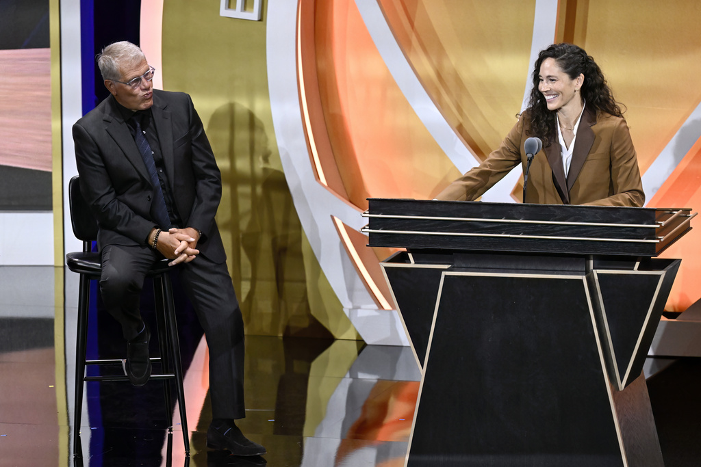Sue Bird, right, pokes fun of Geno Auriemma, left, during her enshrinement in the Basketball Hall of Fame, Saturday, Sept. 6, 2025, in Springfield, Mass. (AP Photo/Jessica Hill)