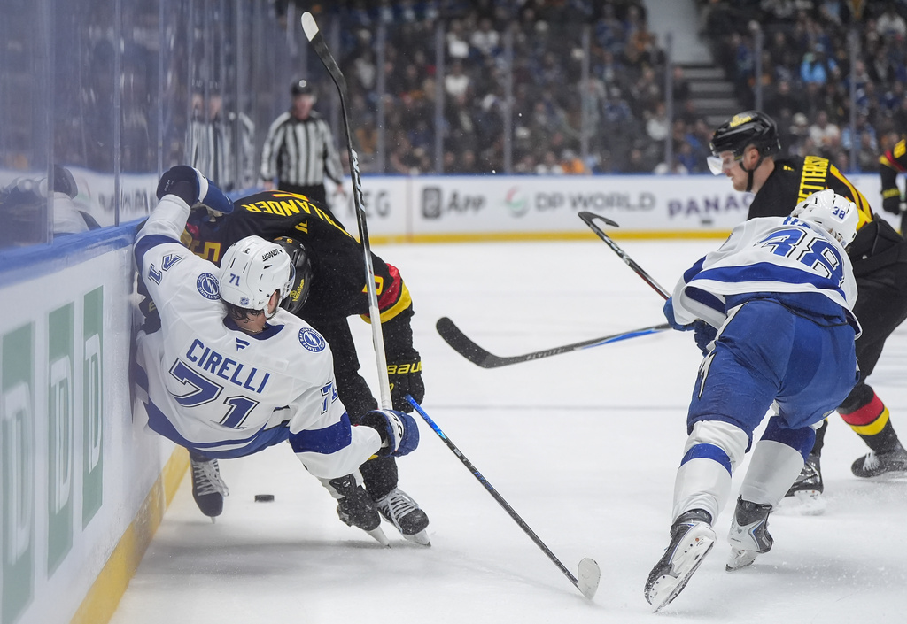 Vancouver Canucks' Tom Willander (5) checks Tampa Bay Lightning's Anthony Cirelli (71) during the first period of an NHL hockey game in Vancouver, British Columbia, Thursday, March 19, 2026. (Darryl Dyck/The Canadian Press via AP)
