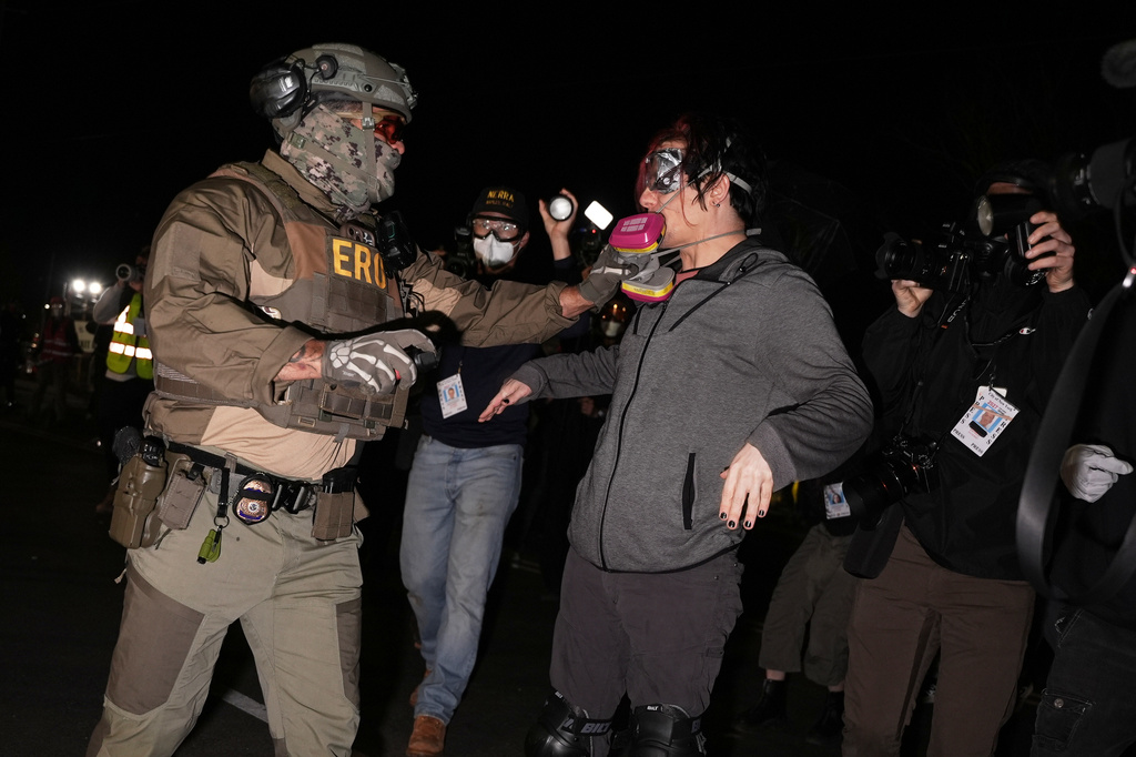A federal immigration officer pulls the respirator mask from a protester outside Delaney Hall detention center Thursday, May 28, 2026, in Newark, N.J. (AP Photo/Angelina Katsanis)