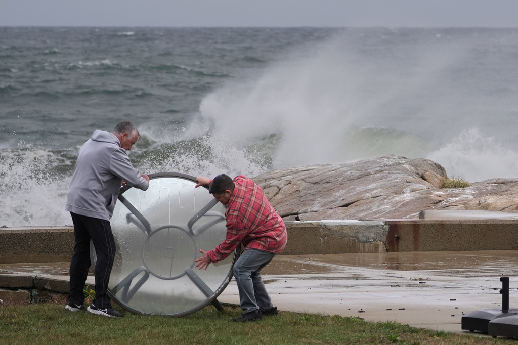 John Garrisi, left, and Gaige Graf move an outdoor table away from the shorefront during the early stages of a nor'easter storm, Friday, Sept. 25, 2026, in Gloucester, Mass. (AP Photo/Robert F. Bukaty)