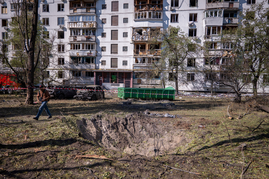 A missile crater is seen in the foreground, of a damaged apartment building following Russia's air attack in Kyiv, Ukraine, Thursday, Sept. 17, 2026. (AP Photo/Dan Bashakov)