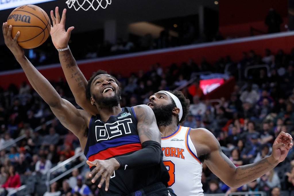Detroit Pistons forward Paul Reed, left, lays up a shot against New York Knicks center Mitchell Robinson, right, during the second half of an NBA basketball game Friday, Feb. 6, 2026, in Detroit. (AP Photo/Duane Burleson)
