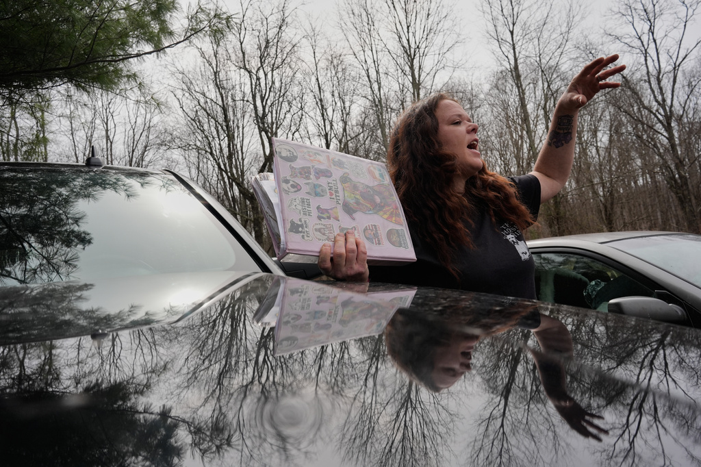 Ashley Nicole Dixon, clutching a binder with the records of pit bulls she has rescued, talks about her rising electric bills outside her home in Danese, W.Va., Saturday, March 21, 2026. (AP Photo/Carolyn Kaster)