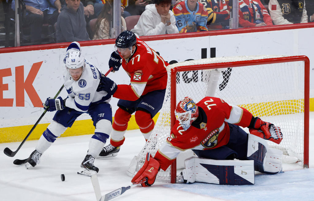Florida Panthers goaltender Sergei Bobrovsky (72) and defenseman Niko Mikkola (77) defend the goal against Tampa Bay Lightning center Jake Guentzel (59) during the second period of an NHL hockey game, Saturday, Dec. 27, 2025, in Sunrise, Fla. (AP Photo/Rhona Wise)
