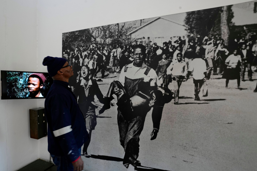 A man looks at June 16 iconic image taken by the late Sam Nzima displayed at The Hector Pieterson Memorial and Museum, in Soweto, South Africa, Monday, June 15, 2026. (AP Photo/Themba Hadebe)
