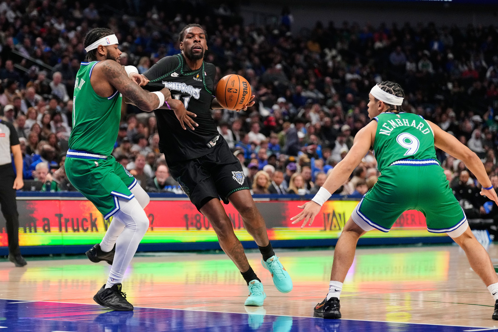 Minnesota Timberwolves' Naz Reid (11) drives to the basket as Dallas Mavericks' Jaden Hardy, left, and Ryan Nembhard (9) defend in the first half of an NBA basketball game Wednesday, Jan. 28, 2026, in Dallas. (AP Photo/Tony Gutierrez)