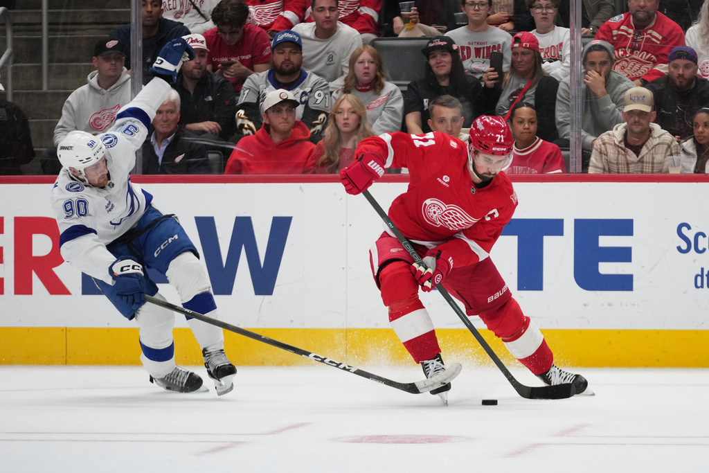 Detroit Red Wings center Dylan Larkin (71) skates past Tampa Bay Lightning defenseman J.J. Moser (90) in the second period of an NHL hockey game Friday, Oct. 17, 2025, in Detroit. (AP Photo/Paul Sancya)
