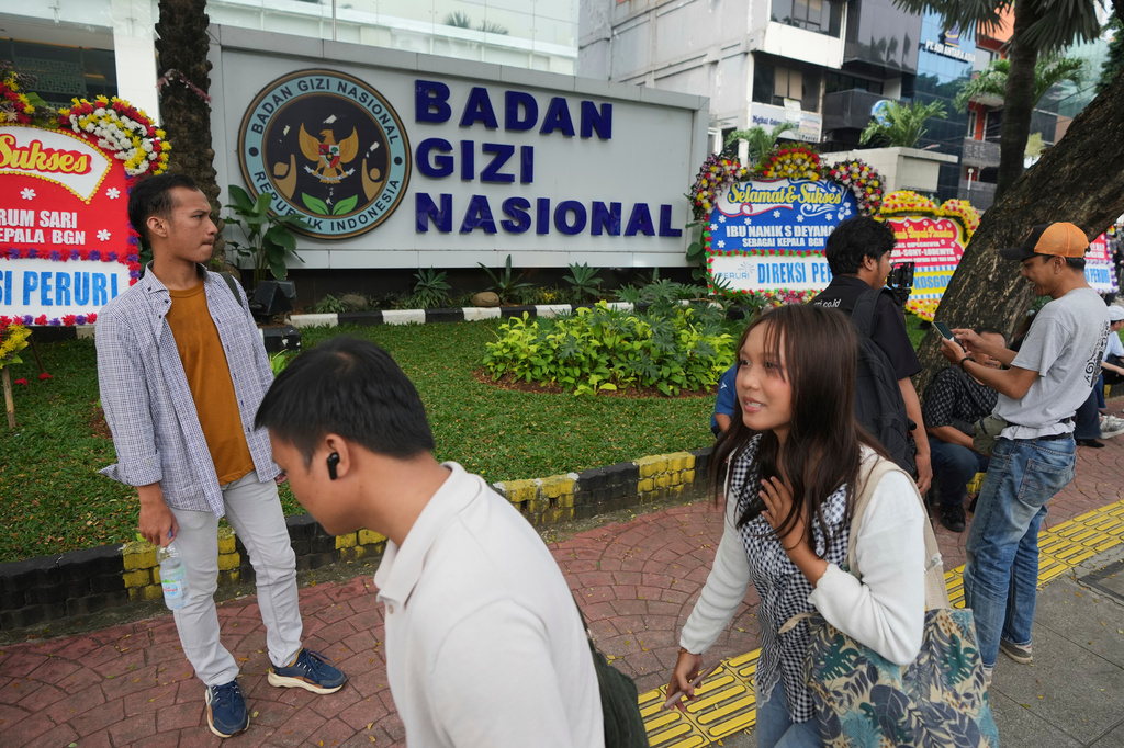 People walk past the office of the National Nutrition Agency as it is being searched by prosecutors, in Jakarta, Indonesia, Wednesday, June 3, 2026. (AP Photo/Dita Alangkara)