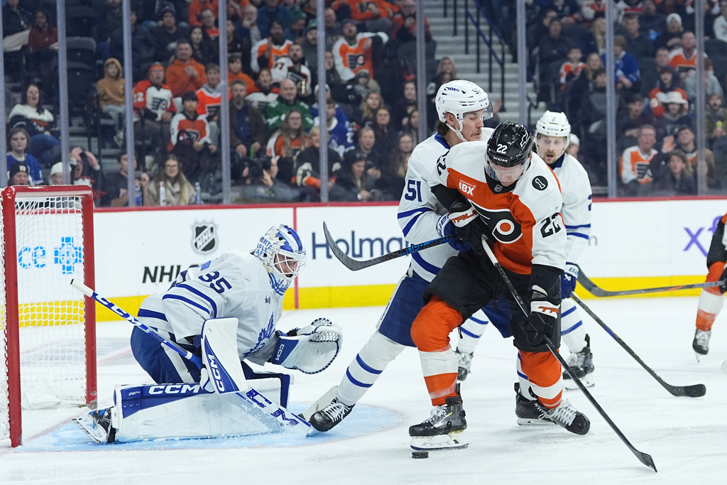 Philadelphia Flyers' Christian Dvorak (22) tries to get a shot past Toronto Maple Leafs' Philippe Myers (51) against goaltender Dennis Hildeby (35) during the second period of an NHL hockey game, Thursday, Jan. 8, 2026, in Philadelphia. (AP Photo/Matt Rourke)