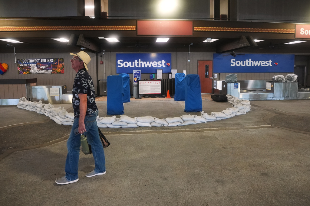A man walks past a closed ticket counter for Southwest Airlines lined with sandbags at Hilo International Airport as Hurricane Nolo sits nearby Friday, Sept. 25, 2026, in Hilo, Hawaii. (AP Photo/Gregory Bull)