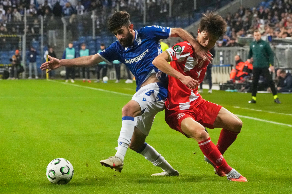 FILE - Lech Poznan's Ali Gholizadeh, left, challenges for the ball with Mainz's Lee Jae-sung during the Europa Conference League soccer match between Lech Poznan and FSV Mainz 05 in Poznan, Poland, Thursday, Dec. 11, 2025. (AP Photo/Czarek Sokolowski, File)