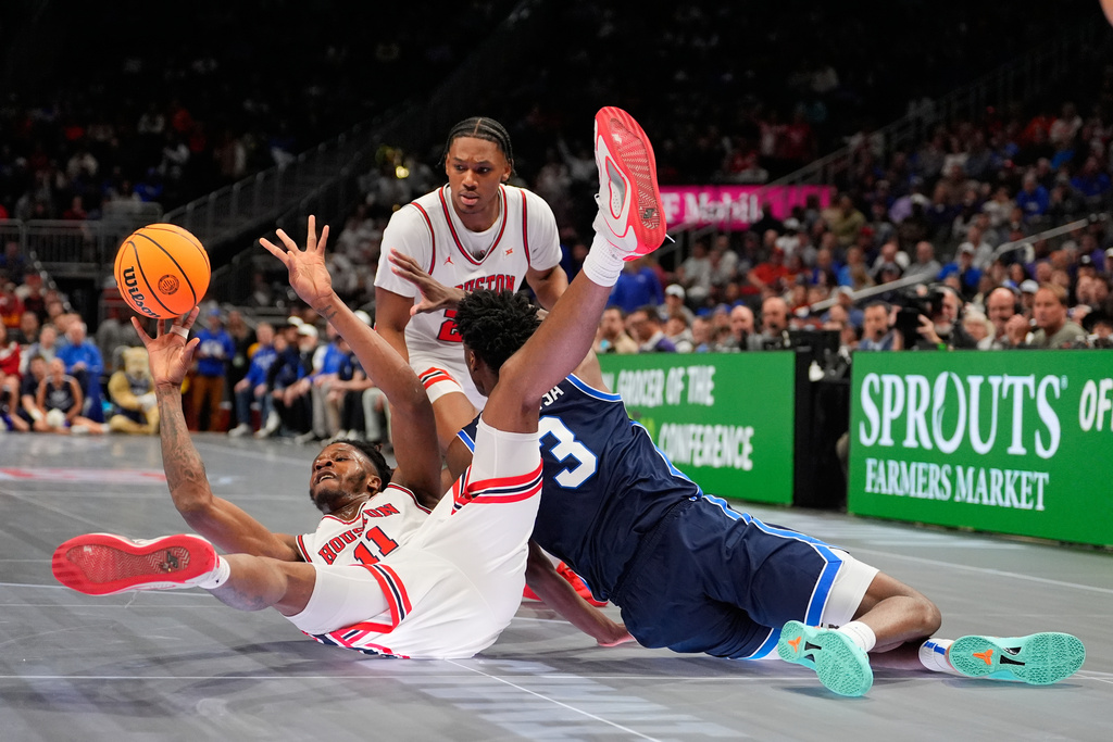 Houston's Joseph Tugler (11) passes as BYU's AJ Dybantsa (3) defends during the first half of an NCAA college basketball game in the quarterfinal round of the Big 12 Conference tournament Thursday, March 12, 2026, in Kansas City, Mo. (AP Photo/Charlie Riedel)