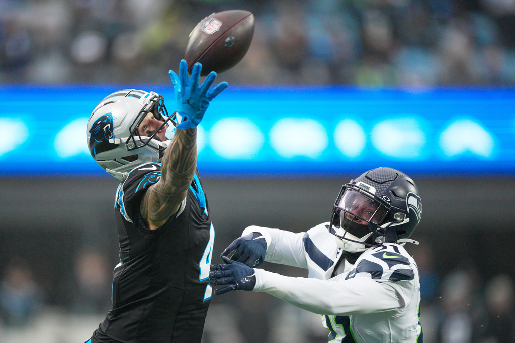Seattle Seahawks cornerback Devon Witherspoon breaks up a pass intended for Carolina Panthers wide receiver Tetairoa McMillan during the first half of an NFL football game, Sunday, Dec. 28, 2025, in Charlotte, N.C. (AP Photo/Jacob Kupferman)