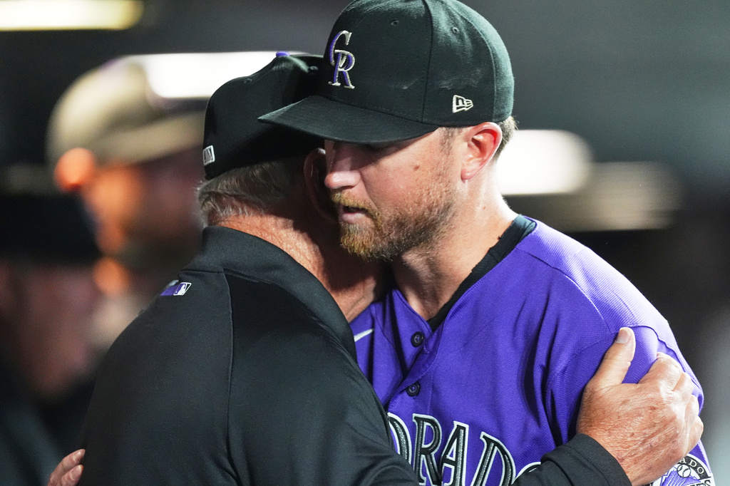 Colorado Rockies starting pitcher Kyle Freeland is hugged as he returns to the dugout after being pulled from the mound in the fourth inning of a baseball game againstt he Arizona Diamondbacks Tuesday, Sept. 22, 2026, in Denver. (AP Photo/David Zalubowski)