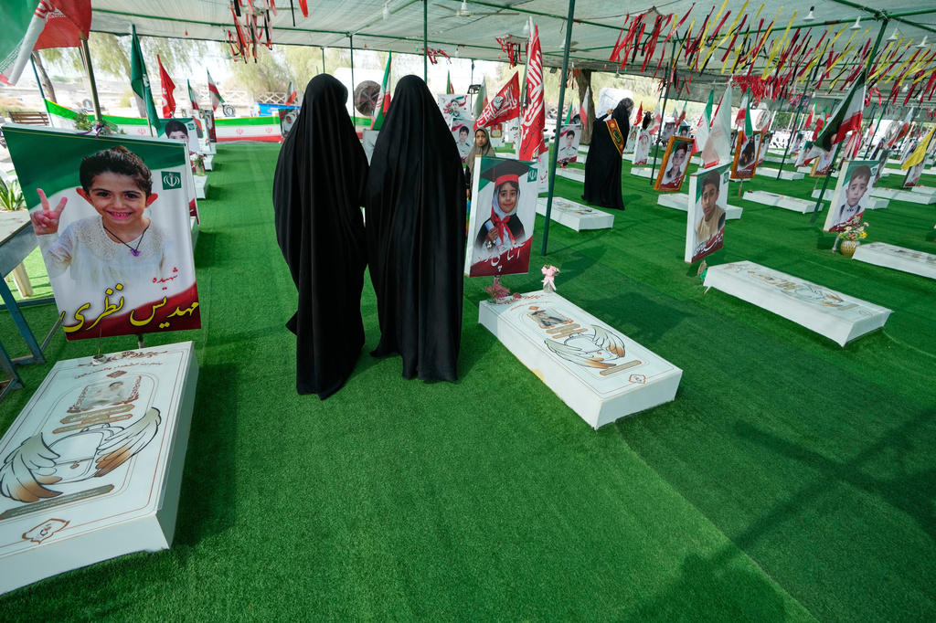 Women walk at the graveyard of the school children who were killed after their school was a hit by a strike on Feb. 28, in town of Minab in southern Iran, Saturday, Sept. 5, 2026. (AP Photo/Vahid Salemi)