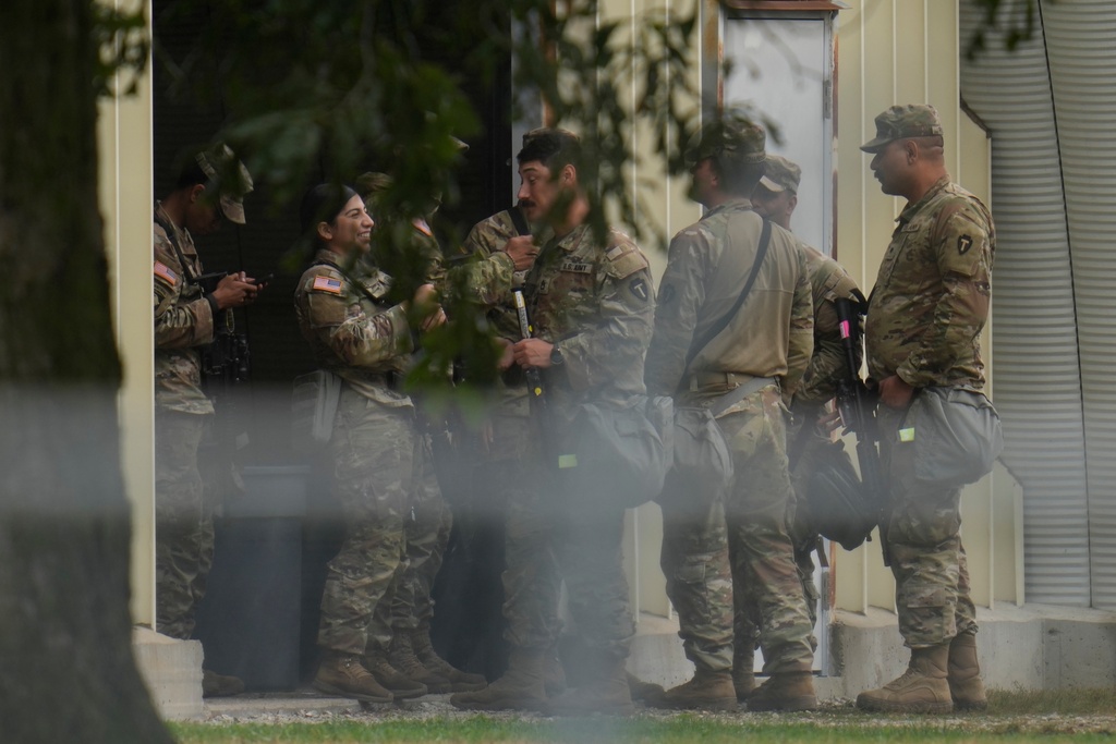 Military personnel in uniform, with the Texas National Guard patch on, are seen at the U.S. Army Reserve Center, Tuesday, Oct. 7, 2025, in Elwood, Ill., a suburb of Chicago. (AP Photo/Erin Hooley)