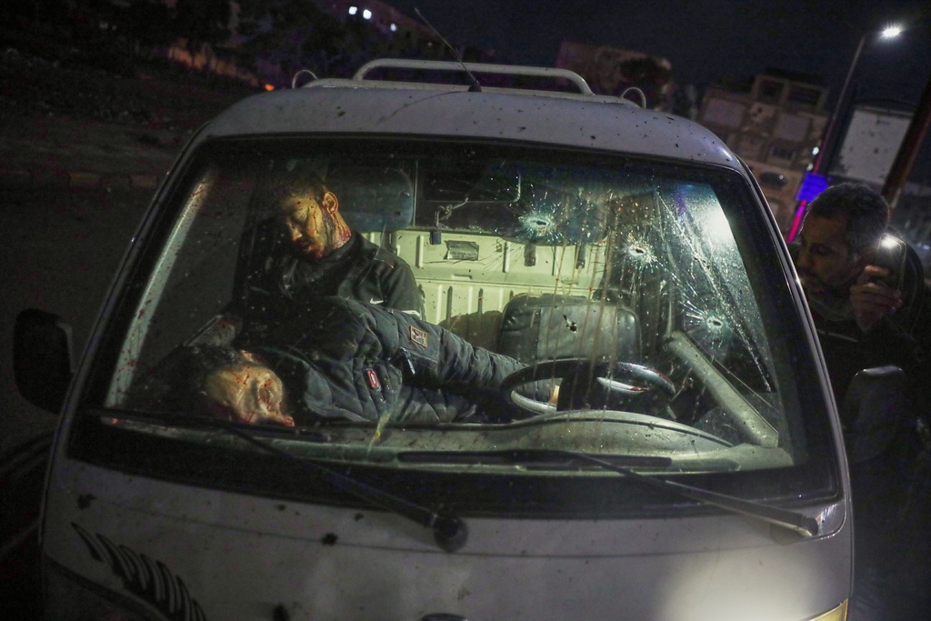 EDS NOTE: GRAPHIC CONTENT - The bodies of two civilians lie inside a car after fighting during the takeover of the city by Syrian government troops from the Kurdish-led, U.S.-backed Syrian Democratic Forces (SDF), in Raqqa, northeastern Syria, Sunday, Jan. 18, 2026. (AP Photo/Omar Albam)
