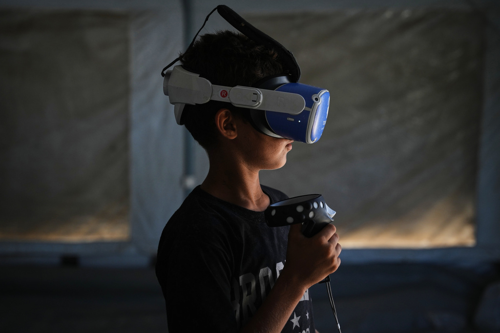 Mohammed Matar, 11, participates in a psychological support session using a virtual reality headset in a tent operated by a medical technology team in Zawaida, central Gaza Strip, Wednesday, June 17, 2026. (AP Photo/Abdel Kareem Hana)