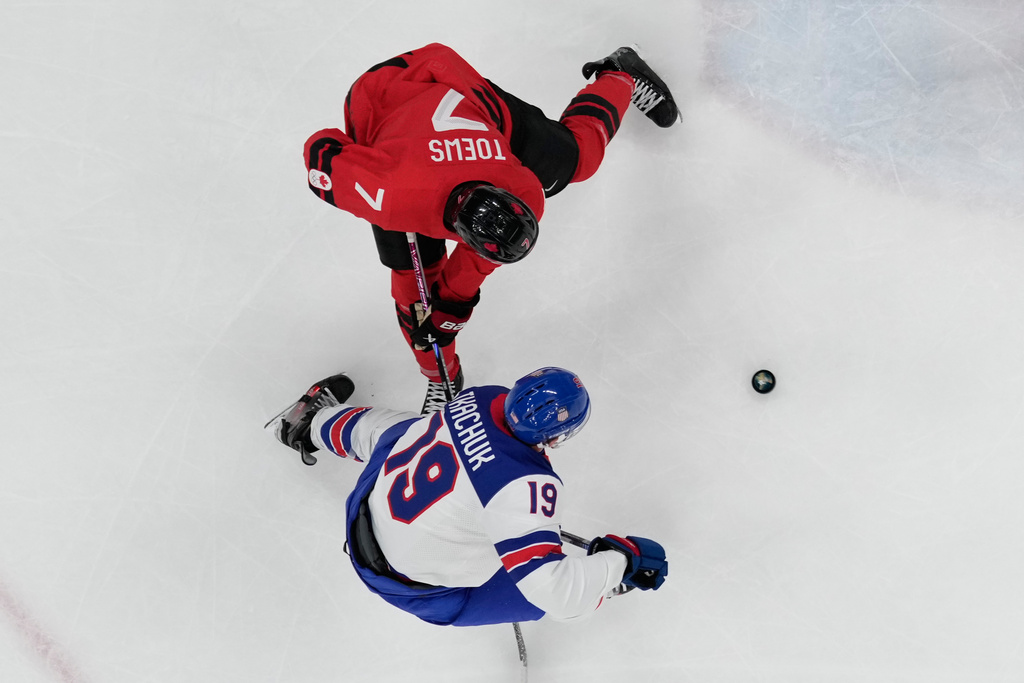 United States' Matthew Tkachuk (19) challenges with Canada's Devon Toews (7) during a men's ice hockey gold medal game between Canada and the United States at the 2026 Winter Olympics, in Milan, Italy, Sunday, Feb. 22, 2026. (AP Photo/Nikos Seimenakis)