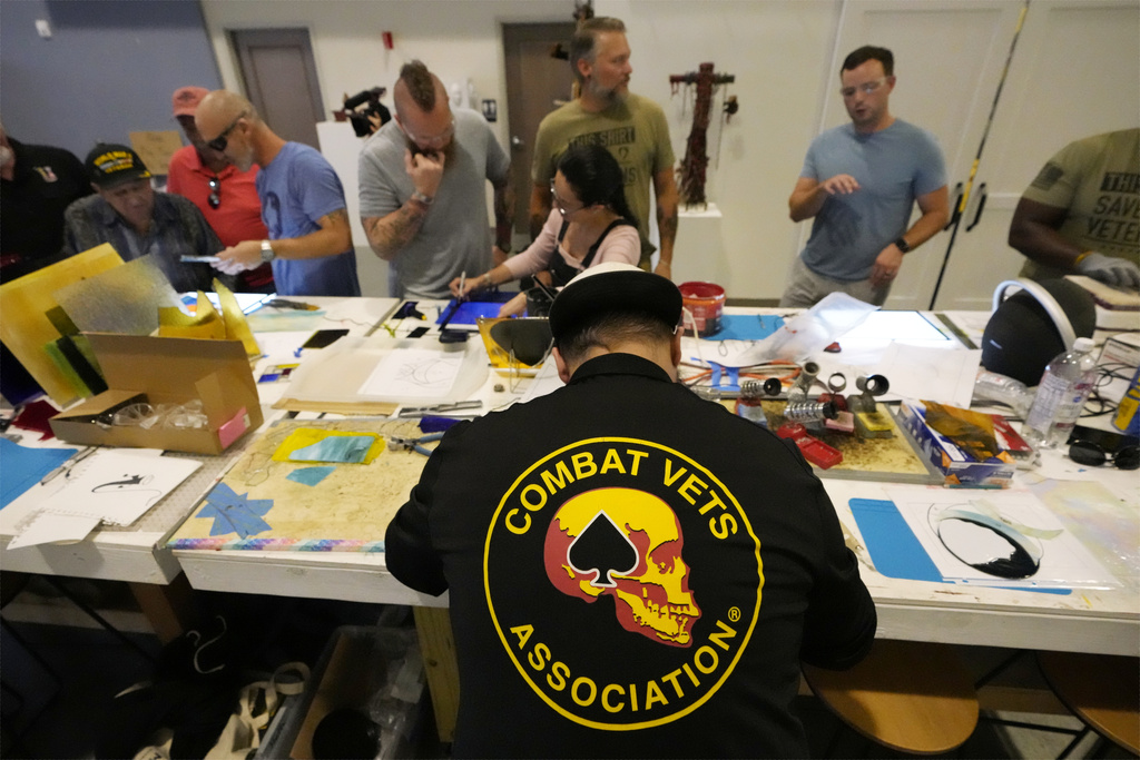 Army veteran Charles Elliott, bottom center, works on a piece of stained glass in the CreatiVets headquarters on Wednesday, Sept. 9, 2025, in Nashville, Tenn. (AP Photo/Mark Humphrey)