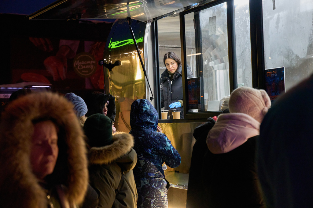 People stand in line for free hot meals that veterans of the 3rd Separate Assault Brigade of Ukraine's Armed Forces serve in residential neighborhood as repeated Russian air attacks on the country's energy sector leave people without power, heating and water in the harshest winter in decades in Kyiv, Ukraine, Sunday, Feb. 8, 2026. (AP Photo/Efrem Lukatsky)