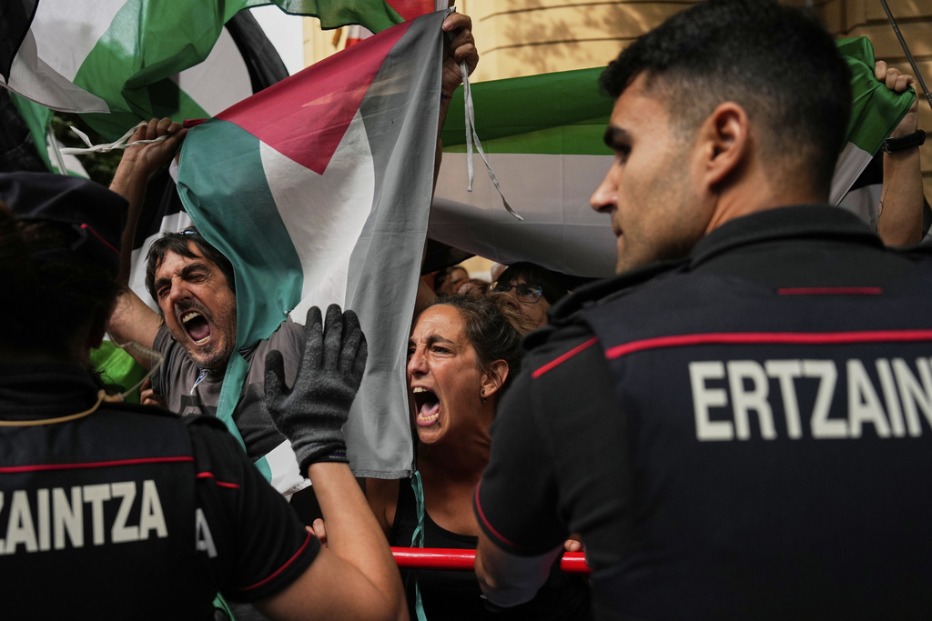 People hold Palestinian flags as they try to disrupt the eleventh stage of the Spanish Vuelta cycling race, from Bilbao to Bilbao, Spain, Wednesday, Sept. 3, 2025. (AP Photo/Miguel Oses)