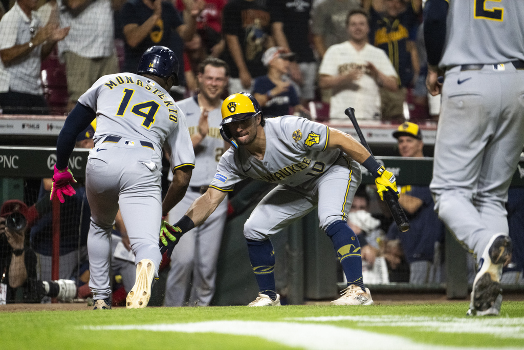 Milwaukee Brewers Andruw Monasterio (14) and Sal Frelick (10) celebrate after Monasterio's home run in extra innings of a baseball game against the Cincinnati Reds, Saturday, Aug. 16, 2025, in Cincinnati. (AP Photo/Michael Swensen)