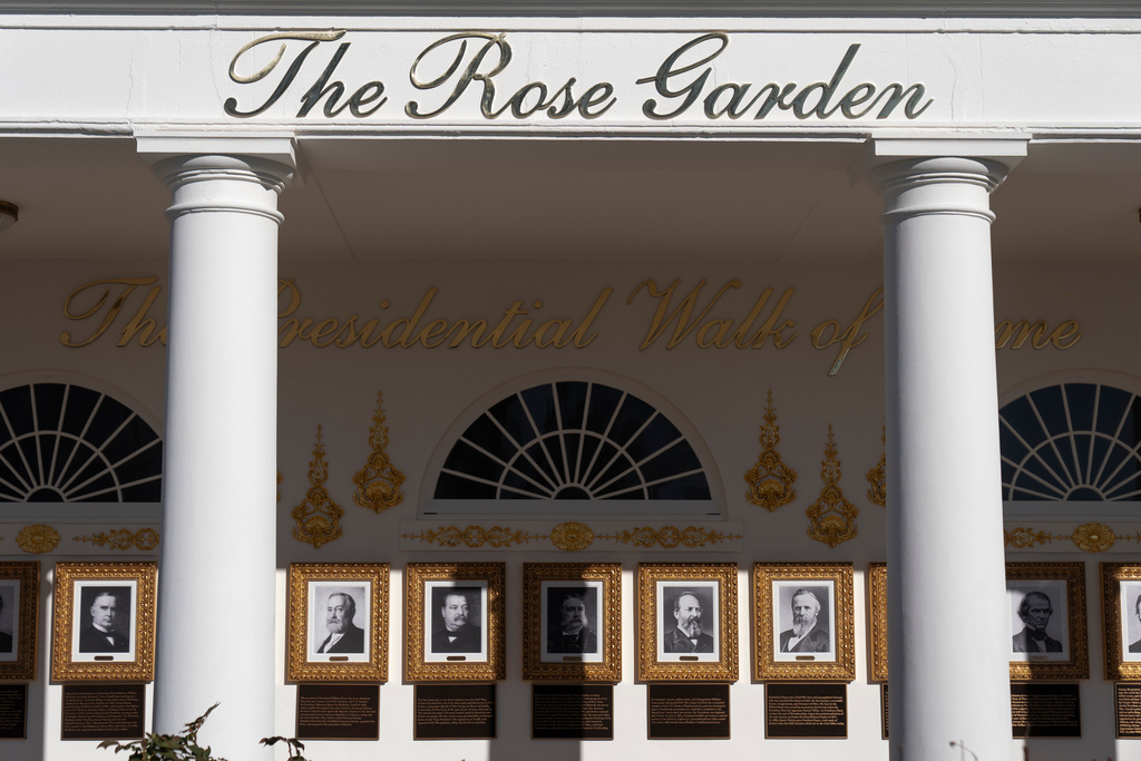 FILE - A sign for the Rose Garden is seen near the Presidential Walk of Fame on the Colonnade at the White House, Jan. 13, 2026, in Washington. (AP Photo/Mark Schiefelbein, File)