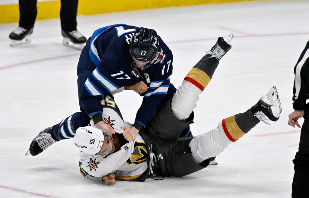 Winnipeg Jets' Adam Lowry (17) fights Vegas Golden Knights' Keegan Kolesar (55) during the first period of their NHL hockey game in Winnipeg, Tuesday Jan. 6, 2026. (Fred Greenslade/The Canadian Press via AP)