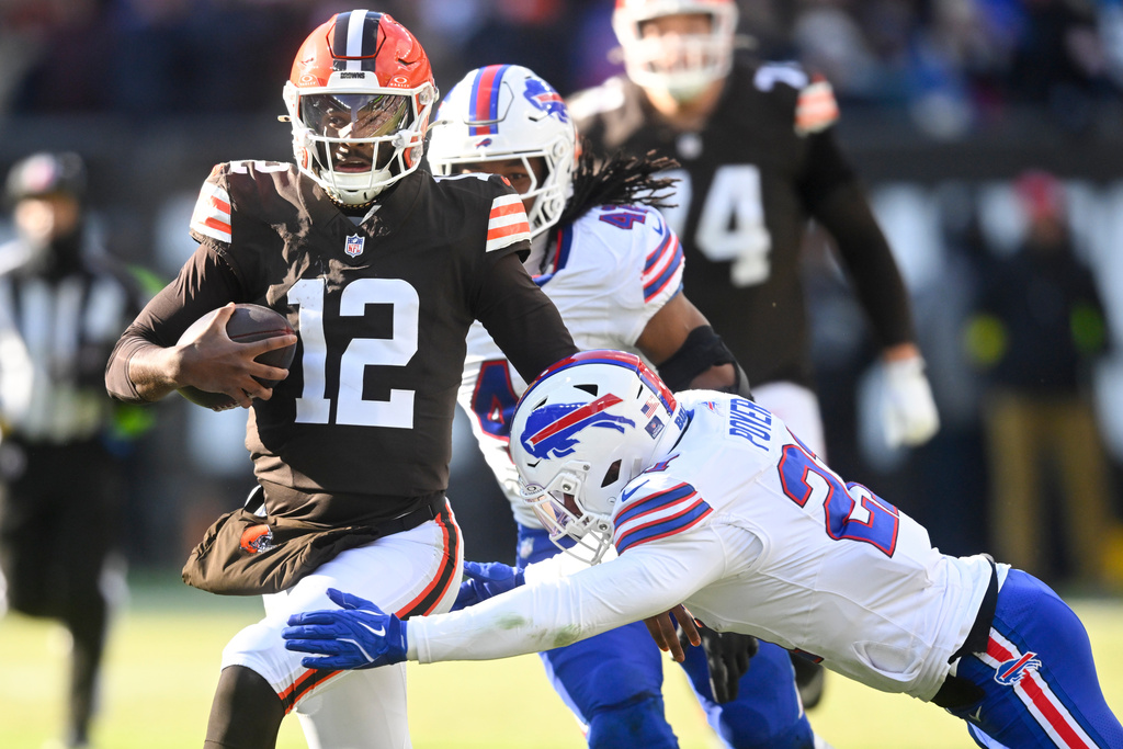 Cleveland Browns quarterback Shedeur Sanders (12) is tackled by Buffalo Bills safety Jordan Poyer during the first half of an NFL football game in Cleveland, Sunday, Dec. 21, 2025. (AP Photo/David Richard)