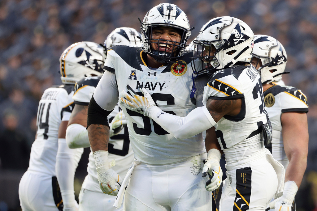 FILE - Navy defensive tackle Landon Robinson (96) celebrates with cornerback Phillip Hamilton (36) during the second half of an NCAA college football game against Army, Saturday, Dec. 14, 2024, in Landover, Md. (AP Photo/Daniel Kucin Jr., File)