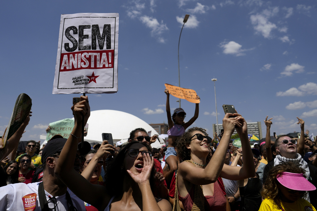 Activists chant "No amnesty" during a protest against an amnesty bill that could absolve former President Jair Bolsonaro and his allies convicted for a 2023 coup attempt, in Brasilia, Brazil, Sunday, Sept. 21, 2025. (AP Photo/Eraldo Peres)