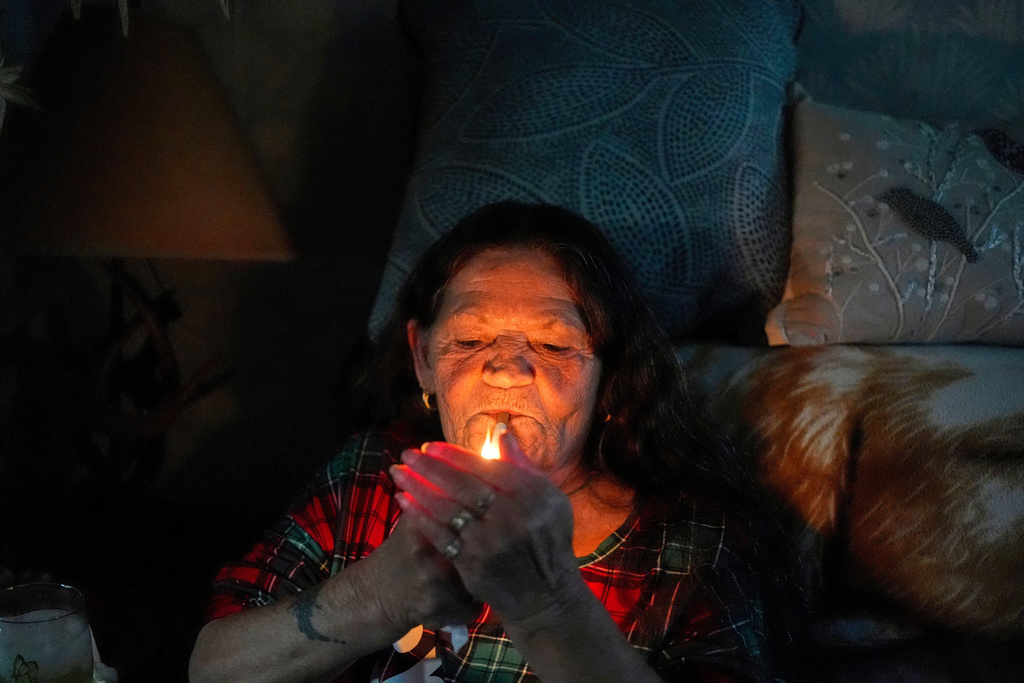 Susan Bushby, a patient at Ammonoosuc Community Health Services, lights a cigarette at her home, Tuesday, Oct. 21, 2025, in Lisbon, N.H. (AP Photo/Robert F. Bukaty)