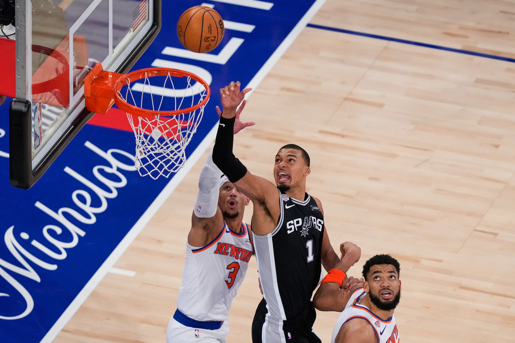San Antonio Spurs forward Victor Wembanyama (1) shoots as New York Knicks guard Josh Hart (3) and center Karl-Anthony Towns (32) defend during the second half of Game 3 of the NBA Finals basketball series, Monday, June 8, 2026, in New York. (AP Photo/Yuki Iwamura)